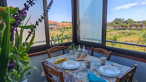 A dining table set for two with a patterned tablecloth, plates, cutlery, and a blue napkin. - Blue Garden Home - Fondachello (Mascali)