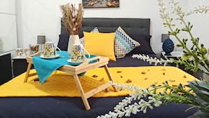A neatly arranged bedroom with a bed, bedside tables, a bedside lamp, a decorative vase, and a framed picture on the wall. - Blue Garden Home - Fondachello (Mascali)