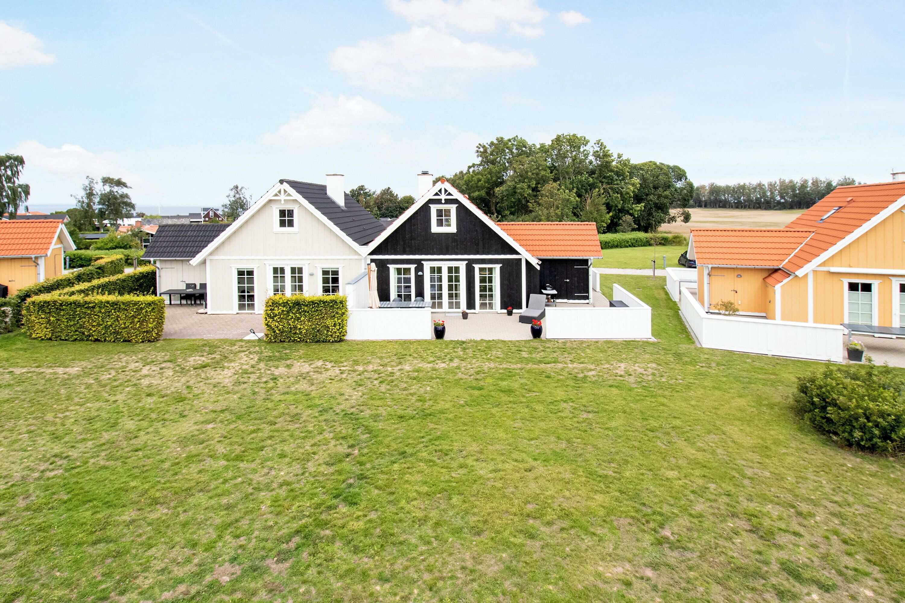 A residential area with houses, a lawn, and a clear sky.