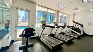 Ein Fitnessraum mit Laufbändern, einem Ergometer und einer Gewichtbank.