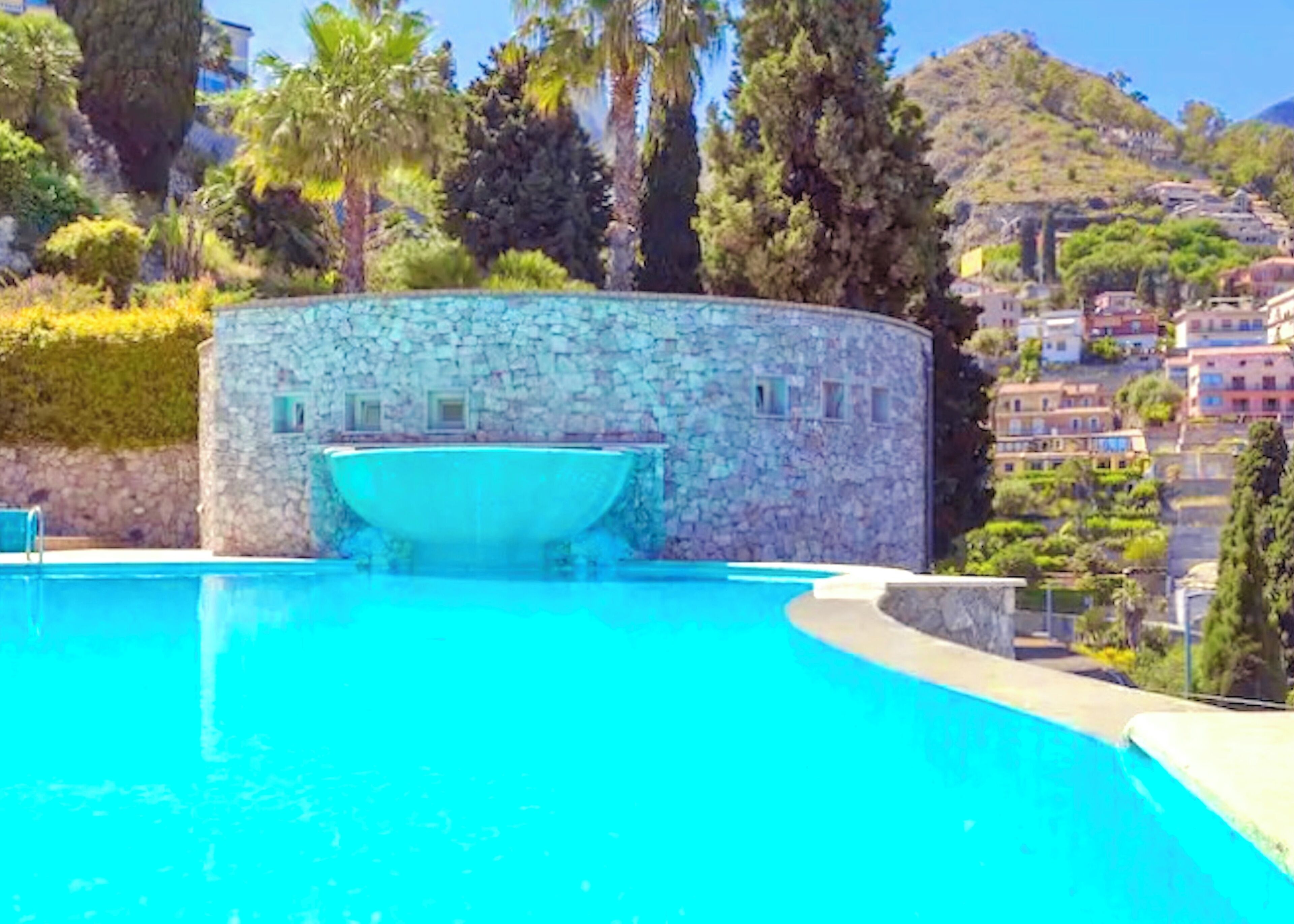 Una piscina con muro de piedra y un bote.