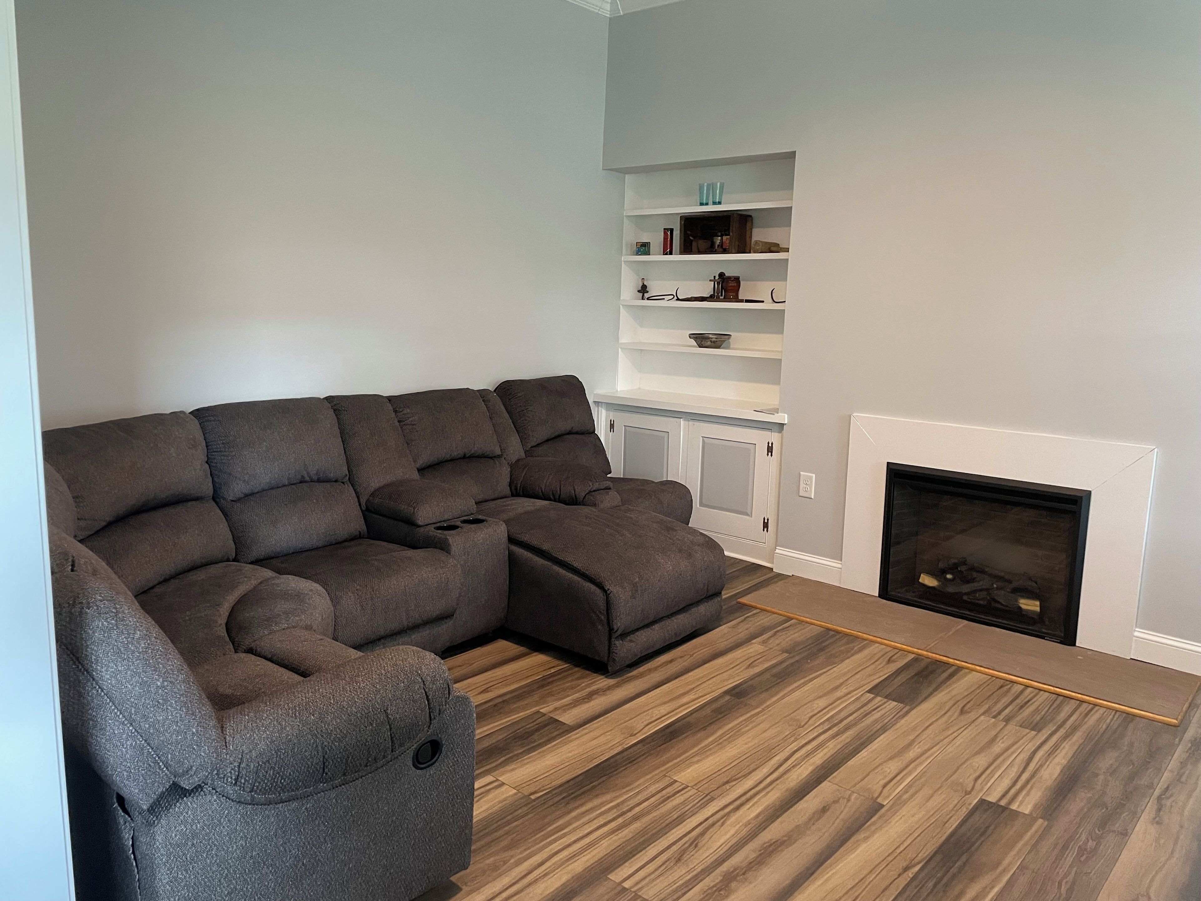 A sectional sofa in a living room with a fireplace and built-in shelves.