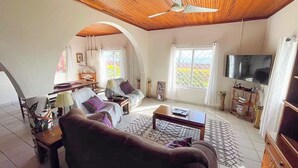 Ein Wohnzimmer mit Sofa, Couchtisch, Fernseher und Holzboden.