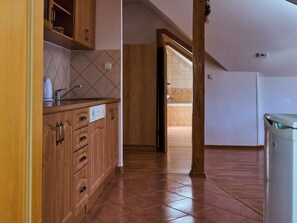 Cocina con armarios de madera, un lavamanos y salpicadero de azulejos.
