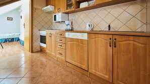A kitchen with wooden cabinets, a microwave, a coffee maker, and a dishwasher. - Harrachov 497 by Interhome (Harrachov)