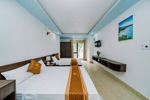 A hotel room with two beds, a TV, a shelf, and a window with curtains. - Phuong Dong Hotel (Hai Phong)