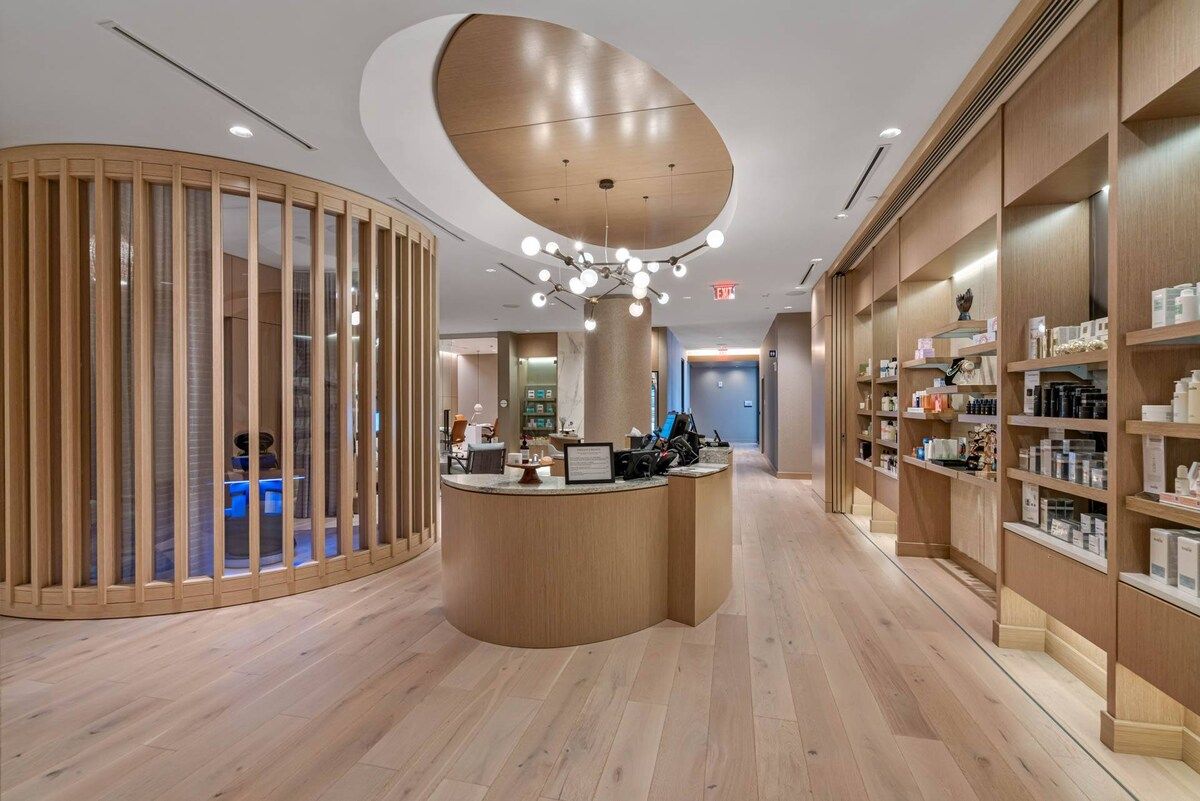 Ein modernes Interieur mit einer Rezeption, Holzregalen und einer geschwungenen Deckenkonstruktion.