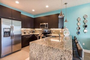 Enjoy cooking in this well-equipped kitchen with a granite island, microwave, coffee maker, and sink.