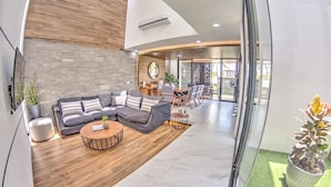 A modern living room with a sofa, coffee table, and dining area.