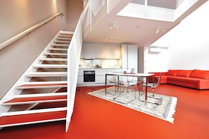 A modern interior with a staircase, kitchen, dining area, and living space. - JULIUS 22: Urban Oasis - 5 Mins to City Center (Wien)