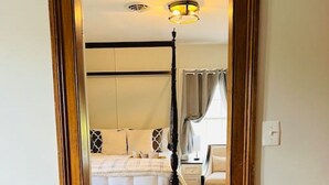 A hotel room with a bed, bedside table, and a chair. - Farm, Fireplaces, Kayaks, River & Mountain Views (Luray)