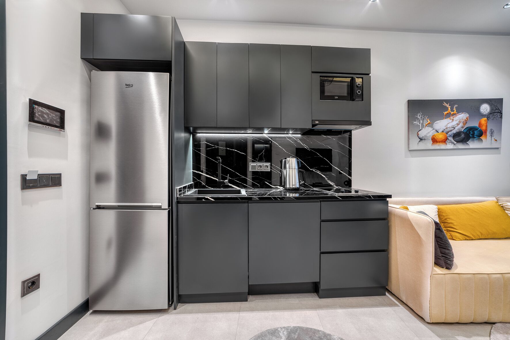 Una cocina moderna con refrigerador, microondas y estufa incorporados.
