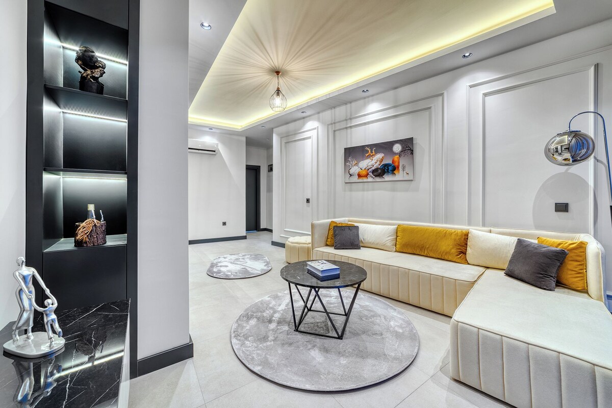 A modern living room with a sofa, coffee table, and artwork on the wall.