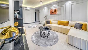 A modern living room with a sofa, coffee table, and a decorative lamp. - Prime Suite Alanya (Alanya)