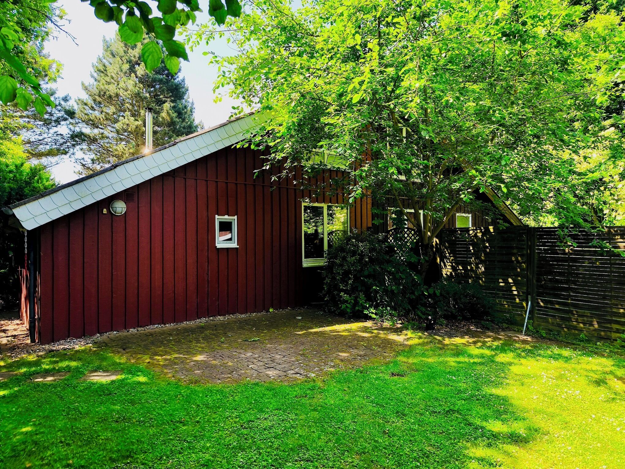A red barn with a sloped roof, a small window, and a door.