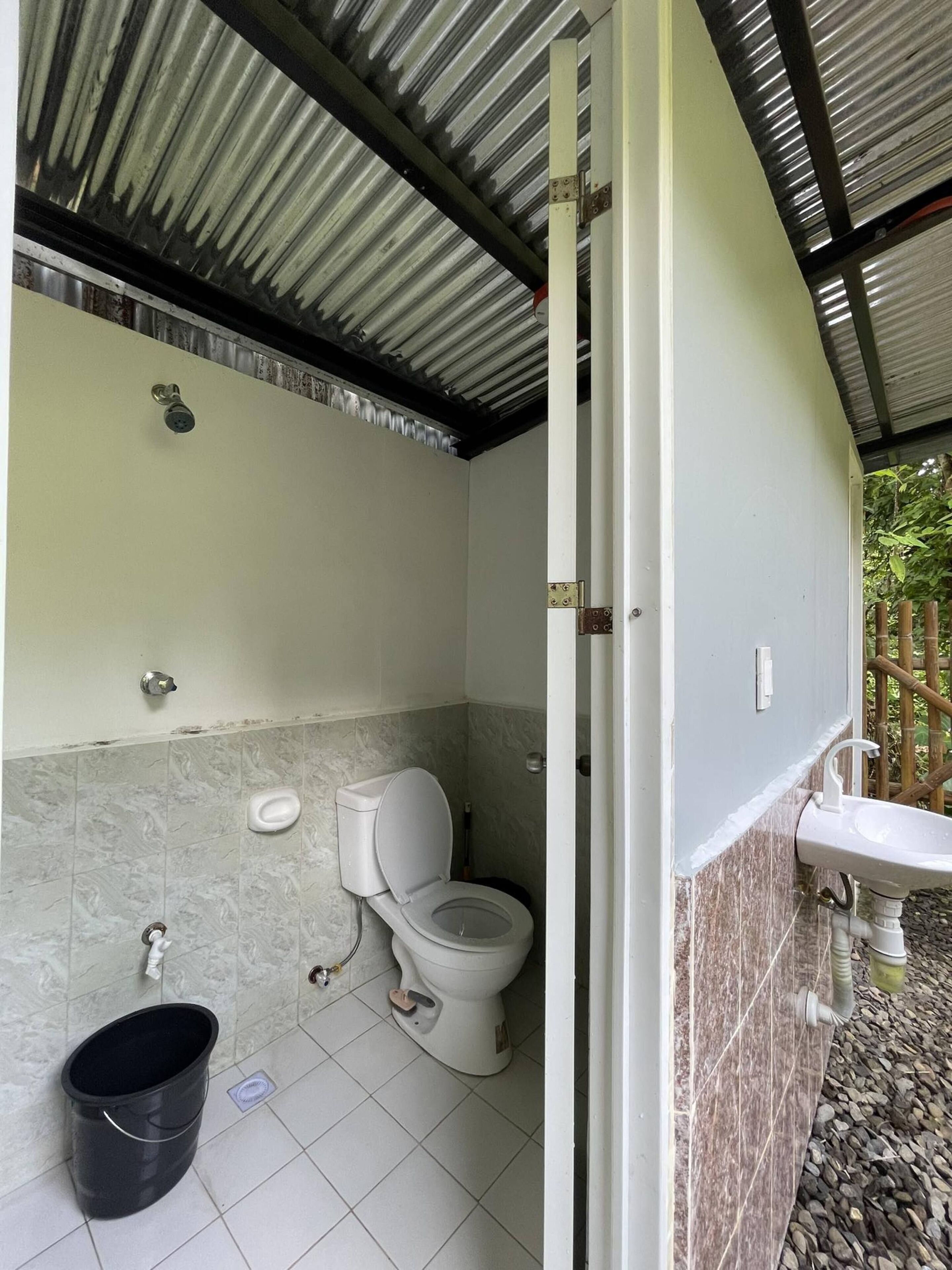 A bathroom with a toilet, sink, and shower.