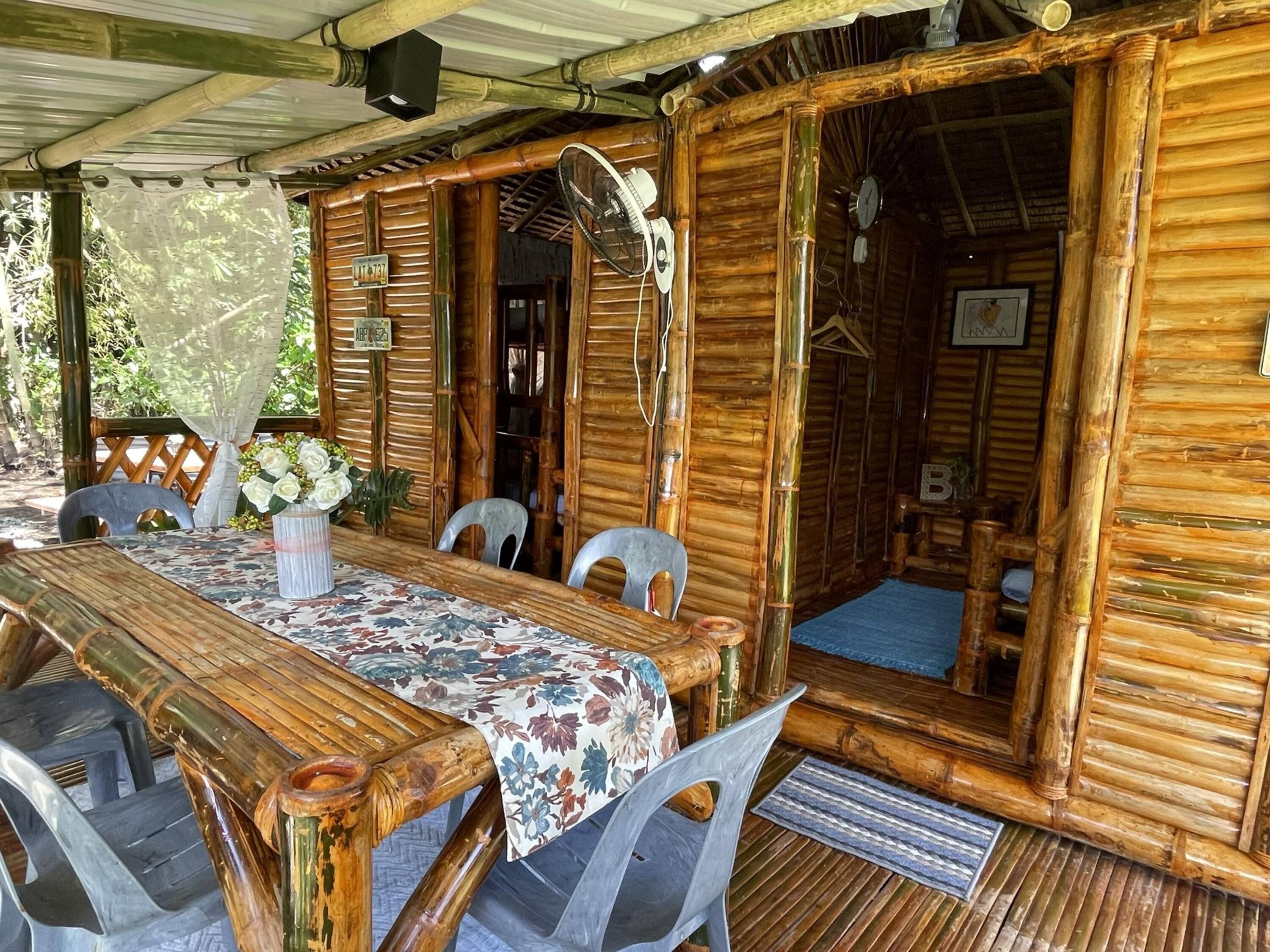 A rustic wooden dining area with a table set for four, surrounded by chairs.