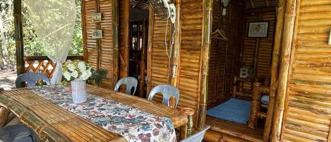 A rustic wooden dining area with a table set for four, surrounded by chairs.