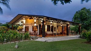 A covered outdoor area with seating and a view of the surrounding garden. - Stunning Gated Property with a Lush Garden, Wrap-Around Terrace & Private Pool (Potrero)