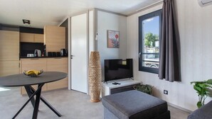A modern living space with a kitchen, dining area, and seating area. - Chalet Familial Avec SPA (Saubrigues)