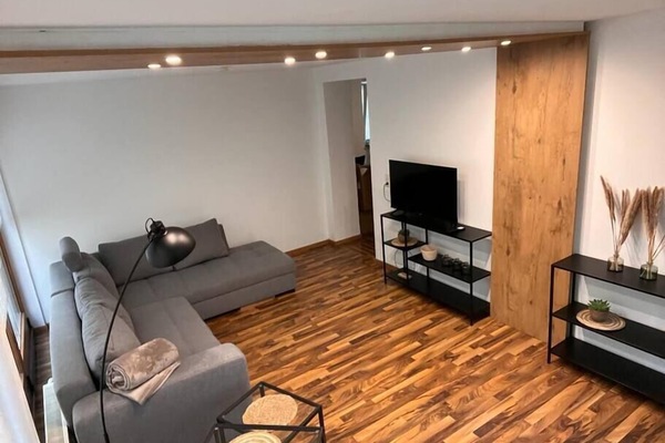 Wohnzimmer mit Schlafsofa und Fernseher im Wintergarten