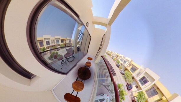 A balcony with a round window overlooking a street. - Romantic Hideaway One Bedroom Villa (Dubai)