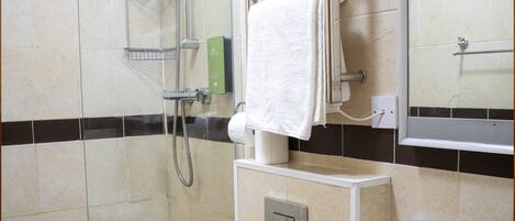 A bathroom with a glass-enclosed shower, a toilet, and a sink.