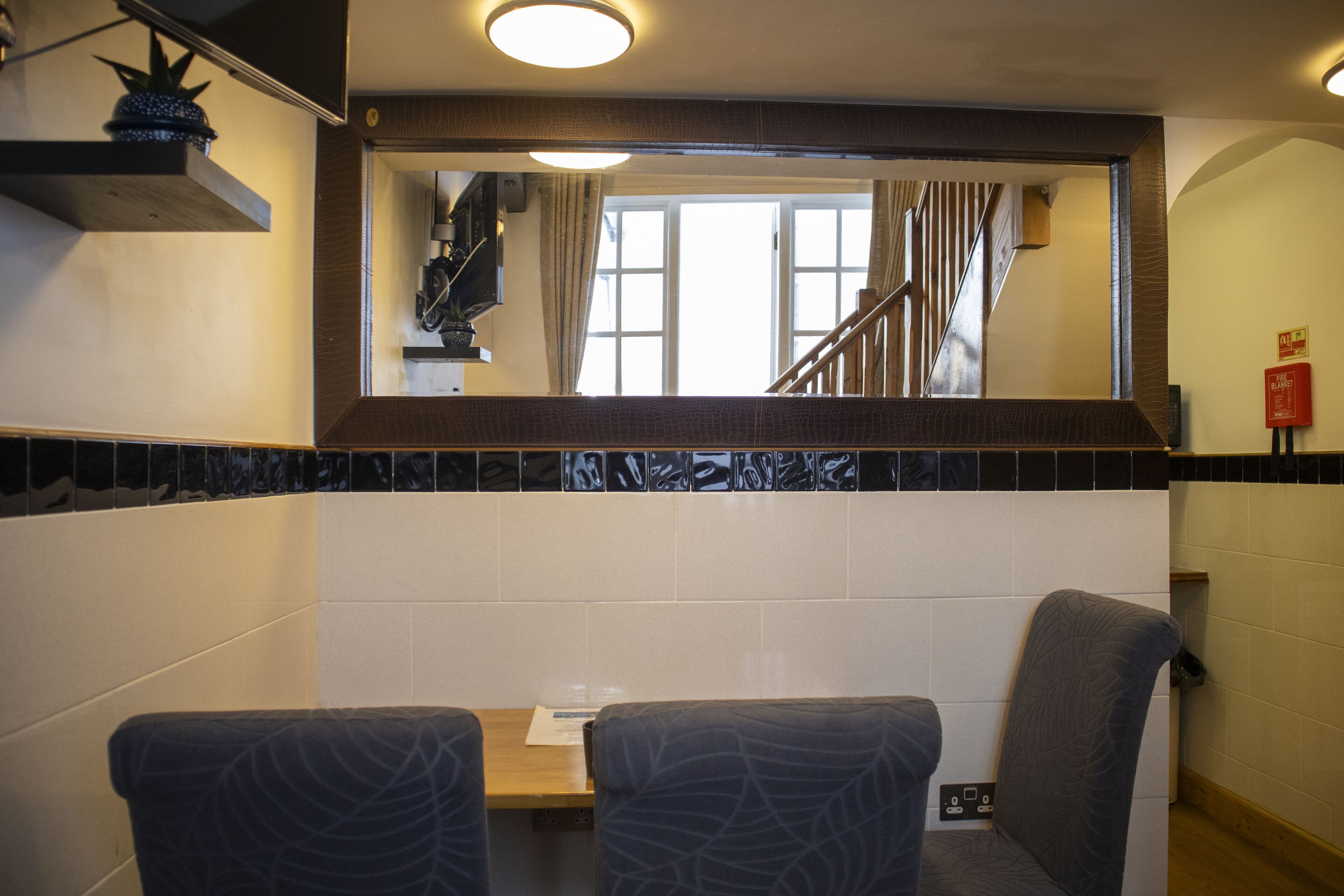 Ein Restaurant mit Blick auf eine Treppe und ein Fenster mit Vorhängen.