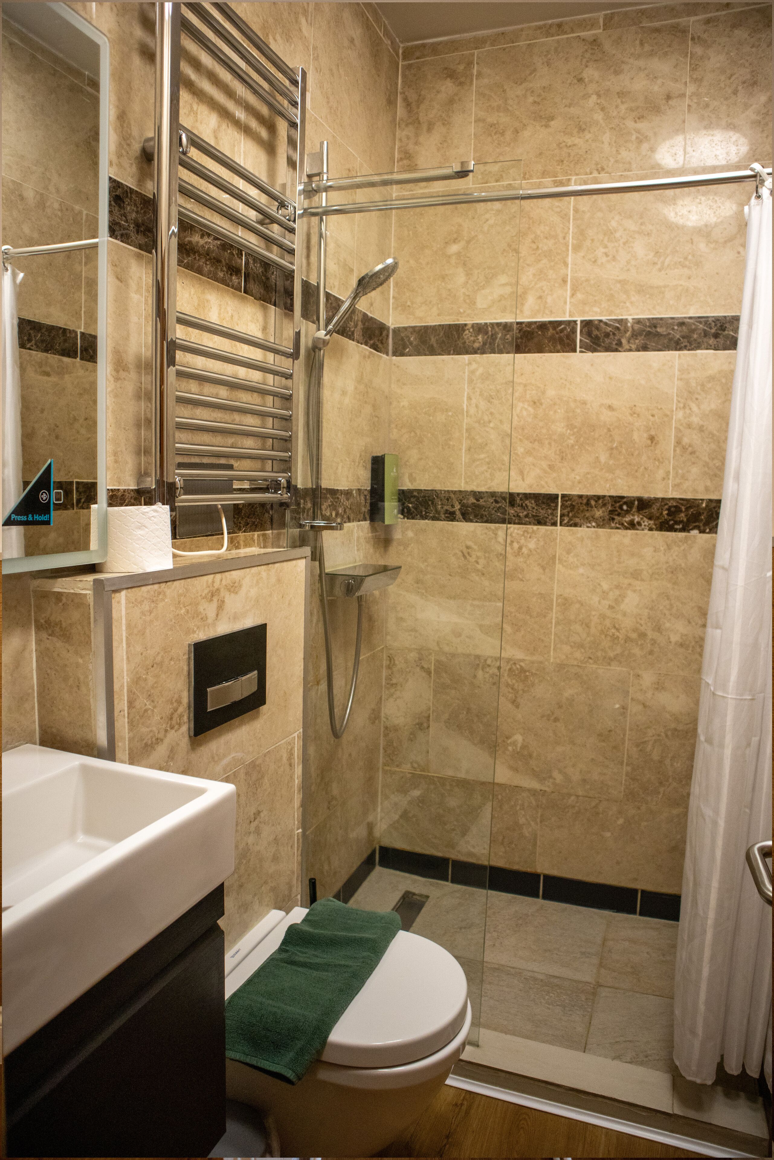 Une salle de bain avec douche, toilettes et lavabo.