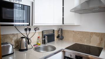 Eine moderne Küche mit Mikrowelle, Toaster, Wasserkocher, Spüle und Herd.
