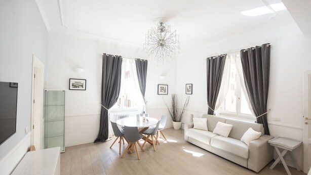 A bright living room with a round dining table, a sofa, and a TV. - St. Peter Beautiful 2BR Apartment (Roma)