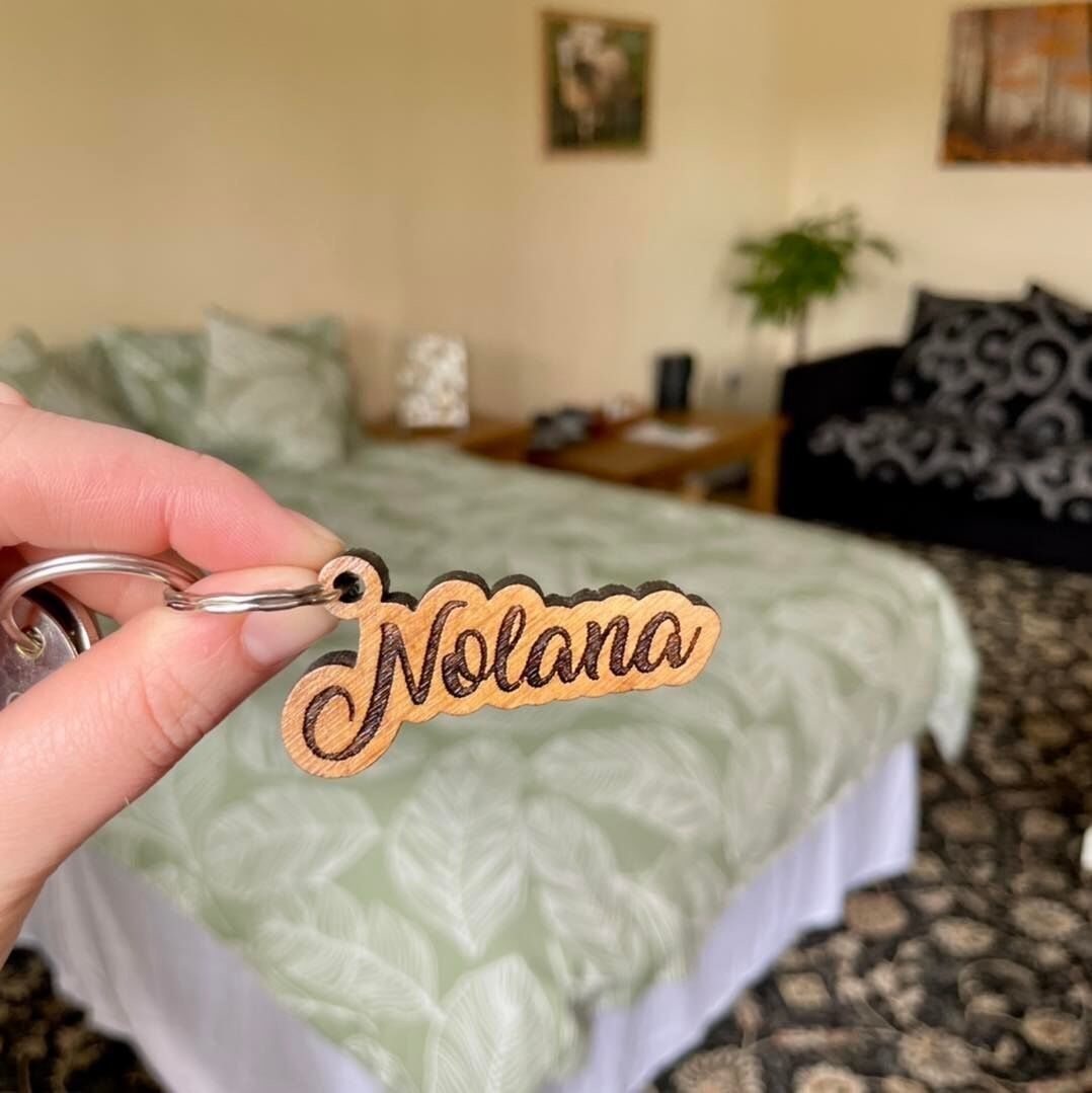 Un porte-clés portant le nom « Nolana » est tenu dans une main.