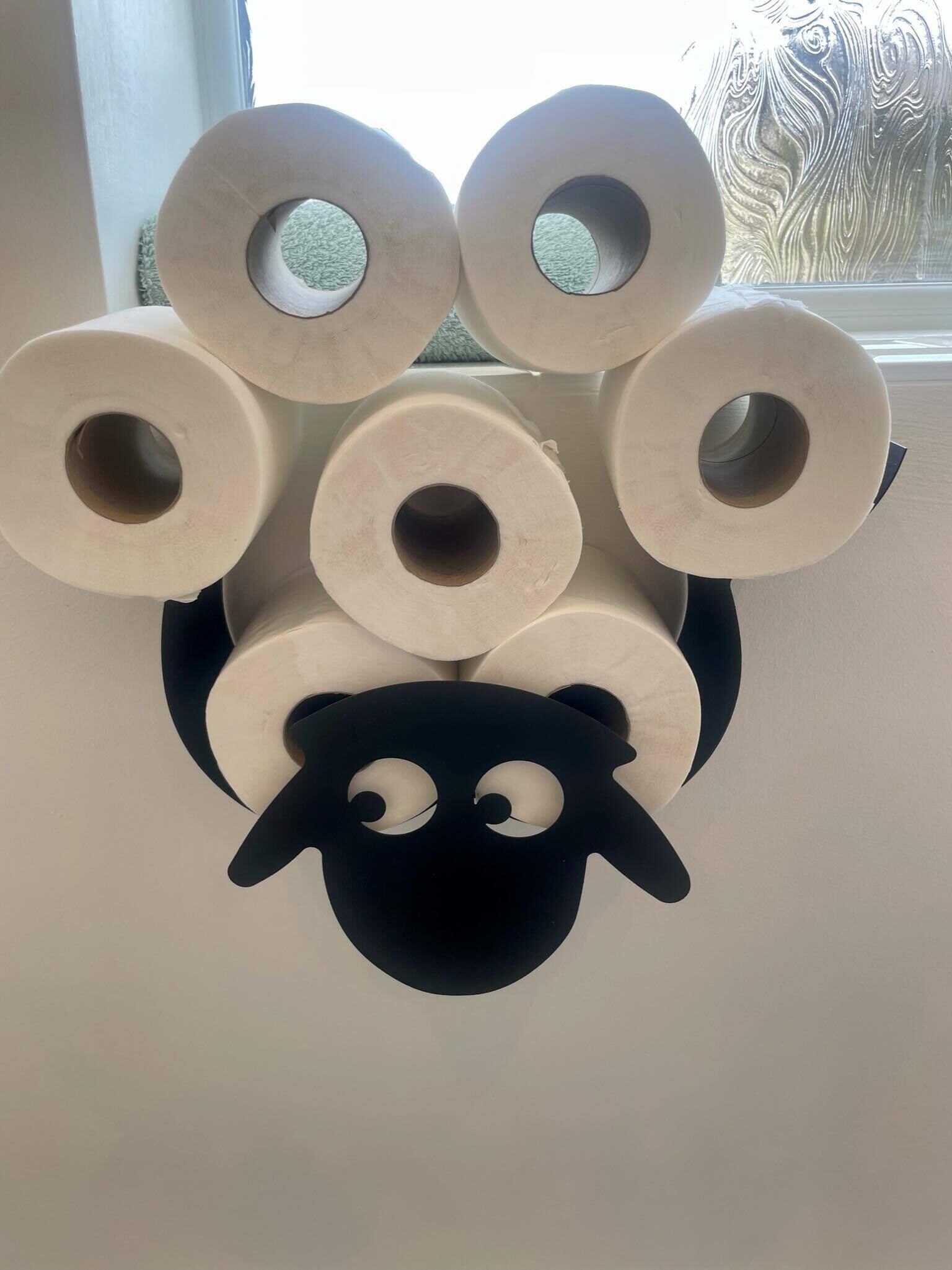 Dispensador de papel higiénico de pared con diseño de oveja.