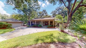 A single-story house with a covered porch, a garage, and a well-maintained lawn.