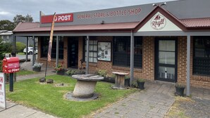 Un bâtiment abritant une épicerie, une boutique de boissons, un bureau de poste et un magasin Rylla.