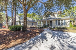A residential property with a paved driveway, a covered porch, and a garage.