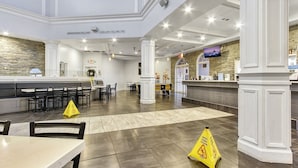 A spacious lobby with a reception desk, multiple seating areas, and a stone accent wall. - 4BR Regal Palms | Lazy River, Slide + Arcade (Davenport)