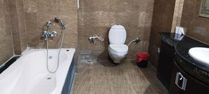 A bathroom with a bathtub, toilet, and sink. - Hotel Galaxy Intercontinental (Gaya)