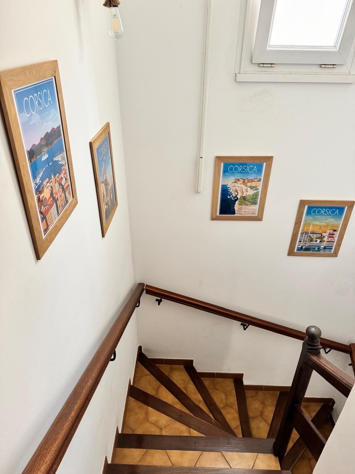 Eine Treppe mit Holzbalkonagen und gefliestem Boden.