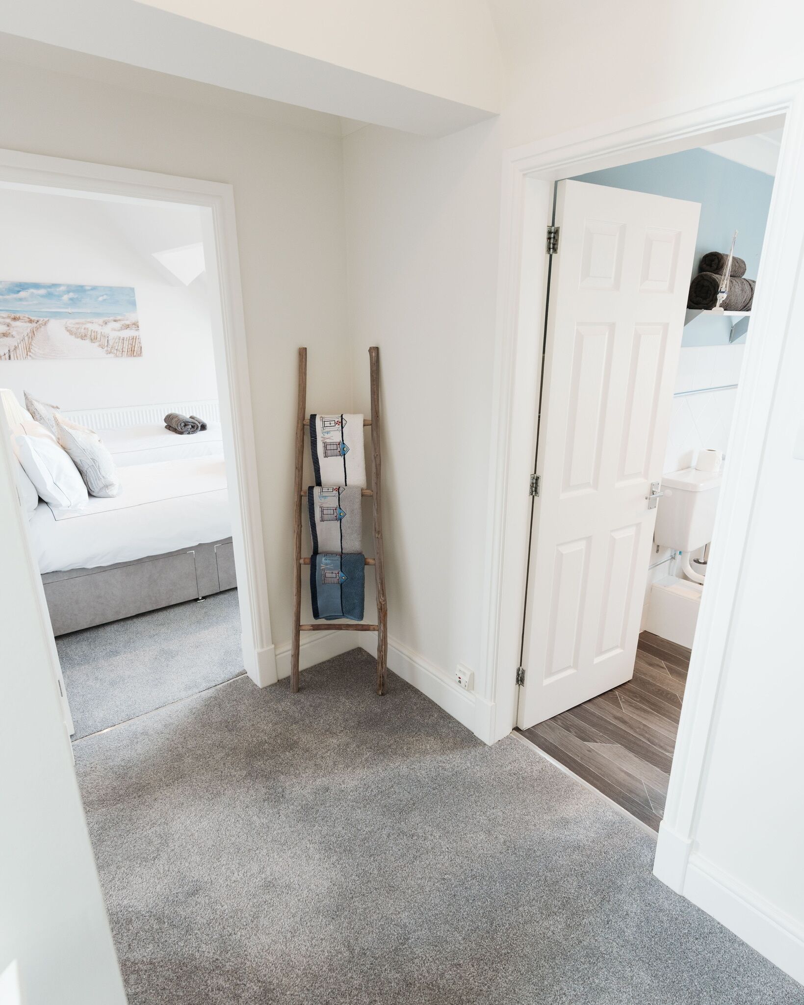 A bedroom with a bed, a ladder, and a door leading to a bathroom.