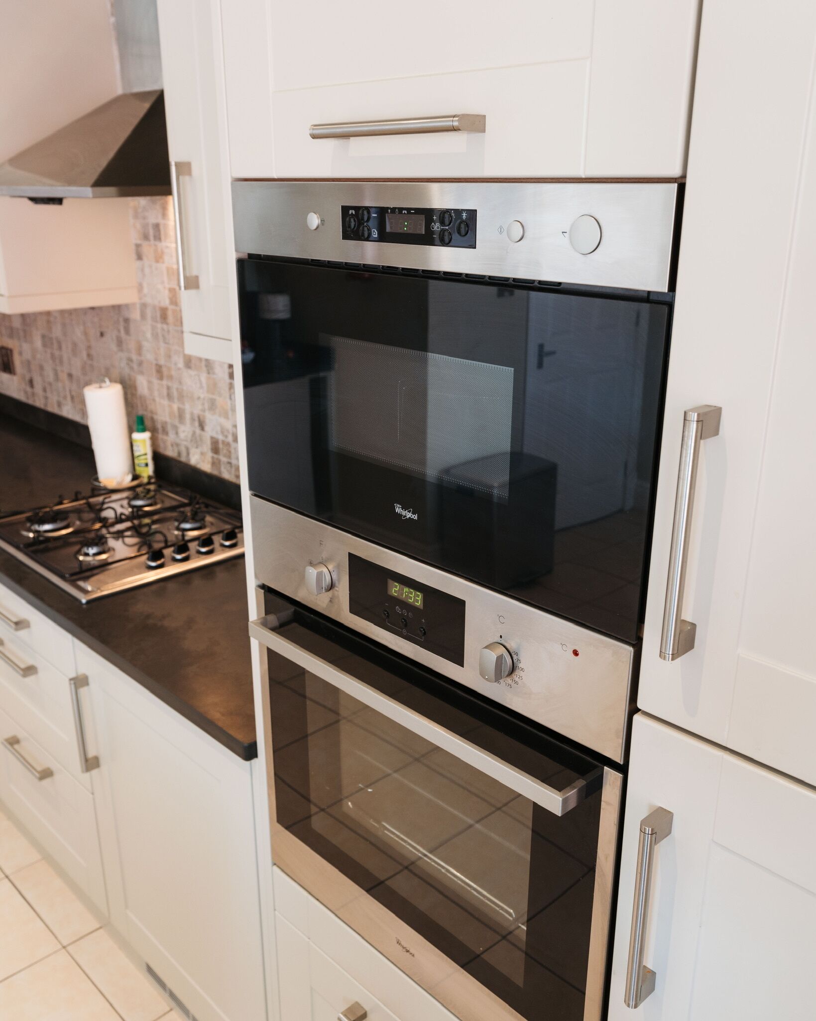 A modern kitchen with stainless steel appliances, including a double oven and a microwave.