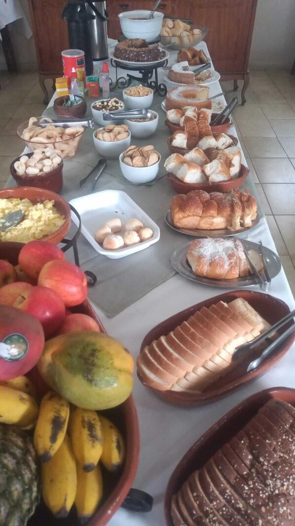 A buffet table with various food items including fruits, pastries, and desserts. - HOTEL PLATINO (Sao Lourenco)