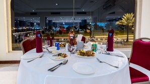 A table set for a meal with plates of food, cutlery, and condiments. - Garden View Hotel (Tabuk)