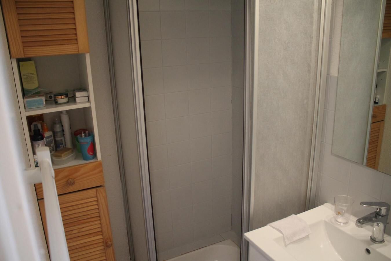 A bathroom with a shower, a sink, and a mirror.