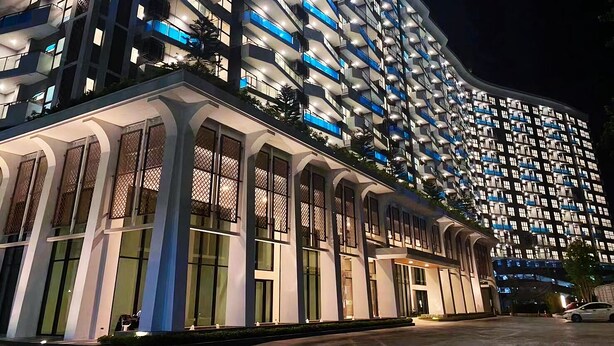 Un hotel de varios pisos con diseño moderno, que cuenta con balcones y ventanas amplias.