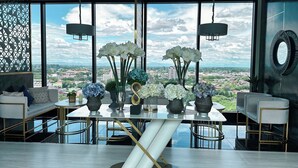 Un comedor moderno con una mesa grande, sillas y vistas a la ciudad a través de amplios ventanales.