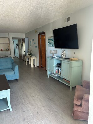 A living room with a sofa, a television, and a cabinet with books.
