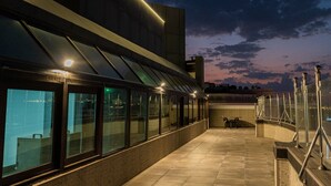 A rooftop terrace with a modern architectural design, featuring a glass railing and a paved walkway. - ODST Jed (Jeddah)