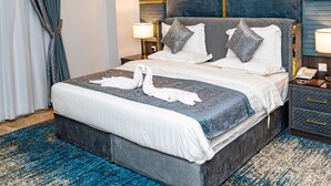 A hotel room with a large bed, a nightstand, a lamp, and a blue patterned carpet. - ODST Jed (Jeddah)
