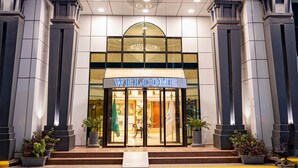 The exterior of the JED Hotel with a 'WELCOME' sign, a modern entrance, and flags. - ODST Jed (Jeddah)